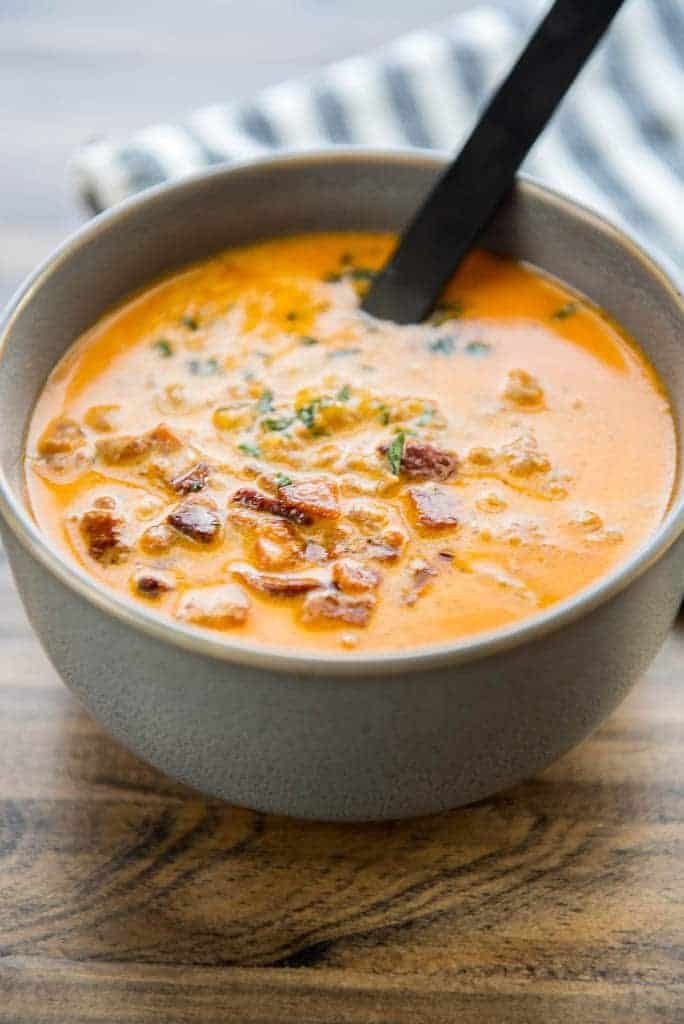 cheeseburger soup in a ceramic bowl with a black spoon