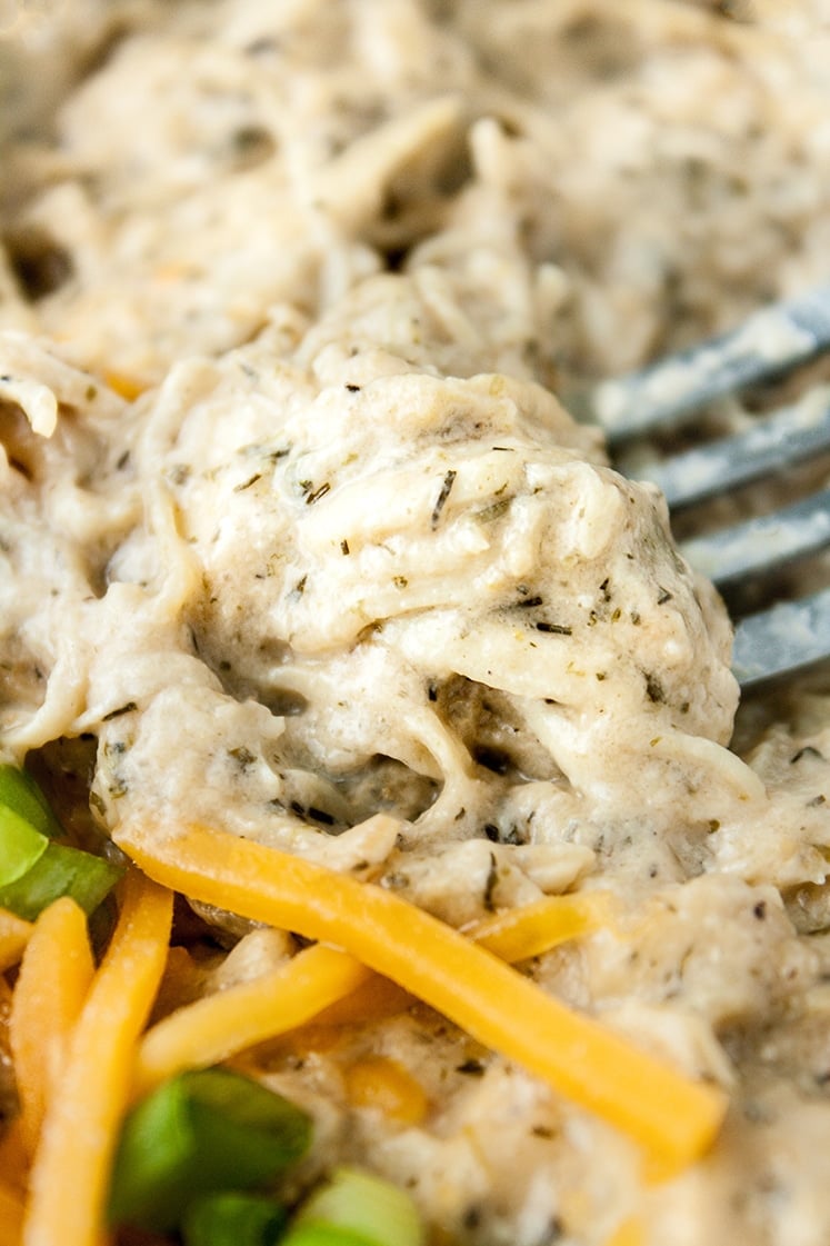 close-up shot of Keto Creamy Ranch Chicken Freezer Meal garnished with cheddar and green onions being scooped by a fork