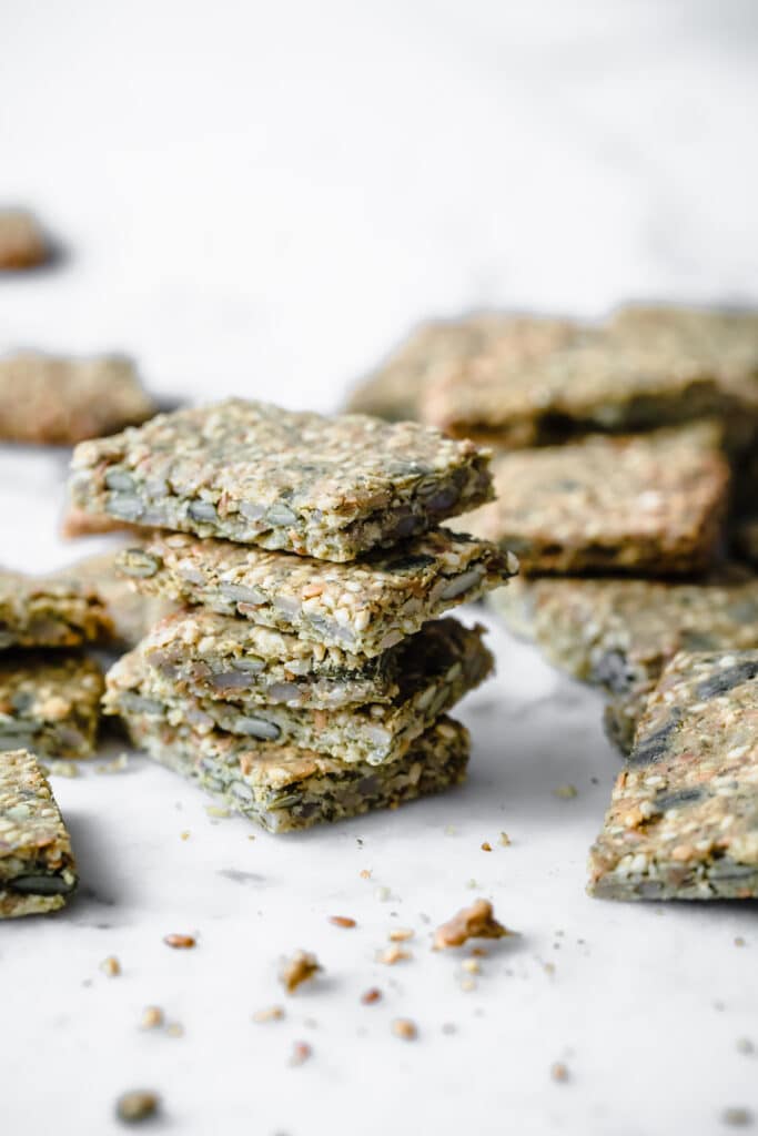 5 nut free keto crackers stacked atop a marble kitchen table