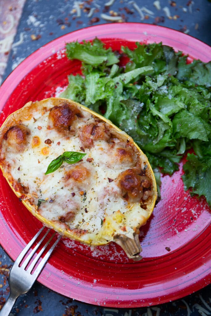 one serving of Spaghetti Squash Lasagna on a red plate garnished with herbs