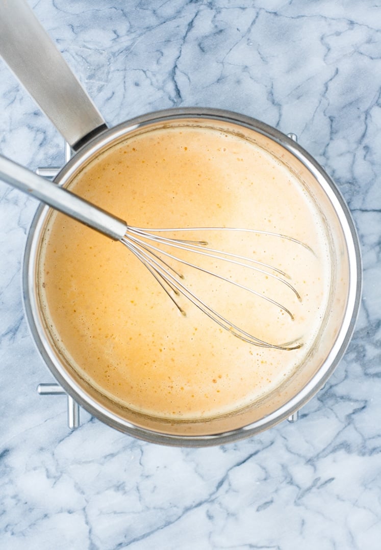 overhead shot of heavy cream mixture and whisk in a saucepan