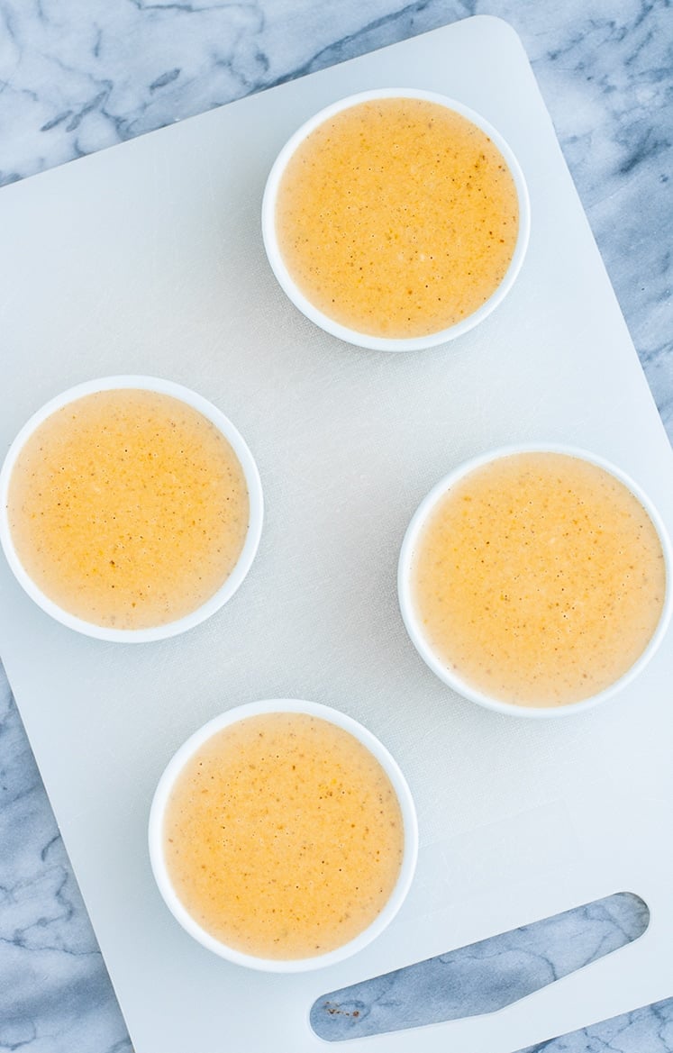 overhead shot of 4 ramekins of pumpkin pie panna cotta resting in room temperature