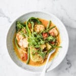 Keto Salmon Coconut Curry: a bowl of Low-Carb Salmon Curry with a fork atop a marble kitchen counter