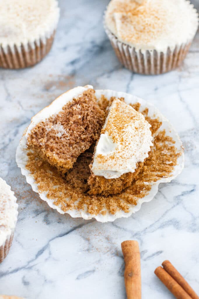 low carb cinnamon roll muffin broken in half atop a marble kitchen counter