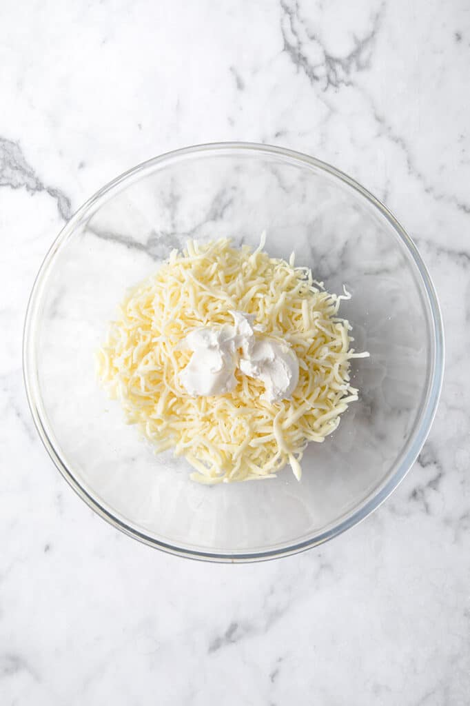 shredded mozzarella cheese and cream cheese in a bowl