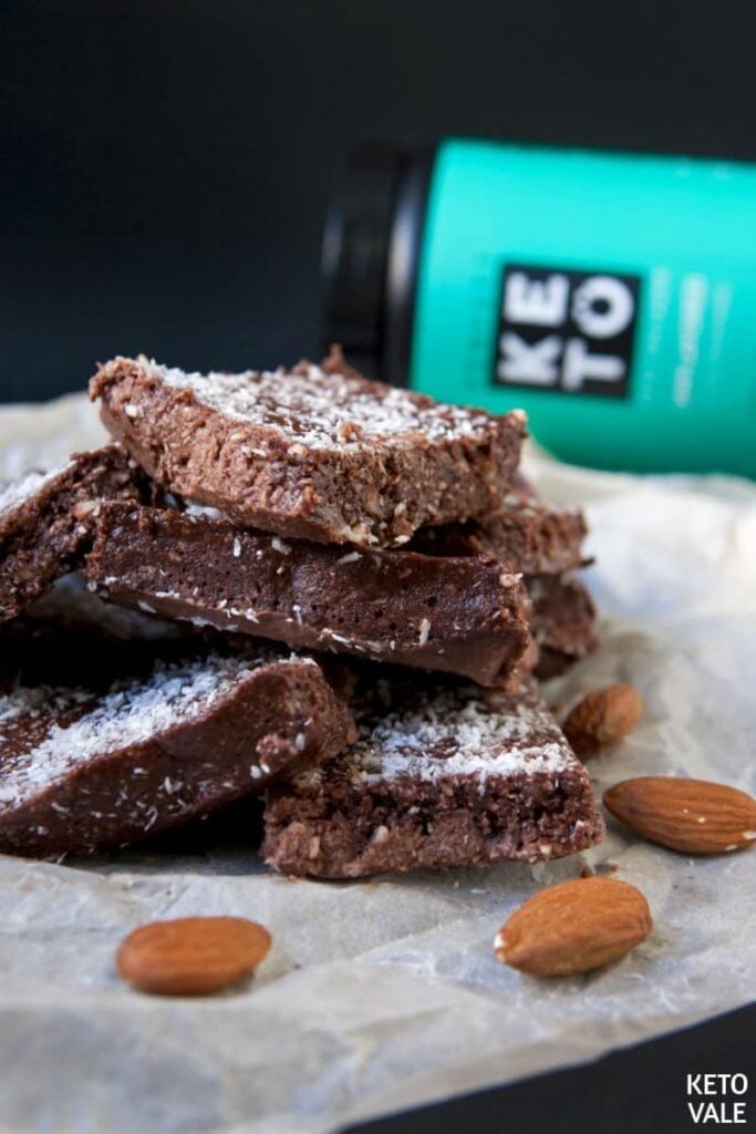 a stack of keto almond coconut protein bars atop a marble kitchen counter