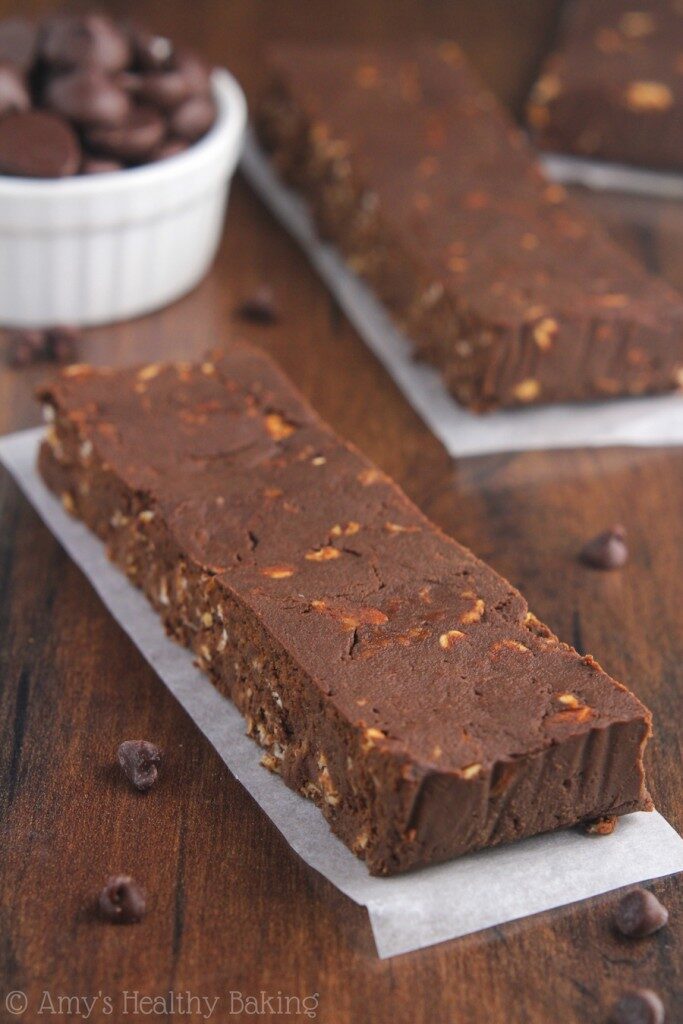 A whole bar of mocha brownie protein bar on a parchment paper atop a wooden table