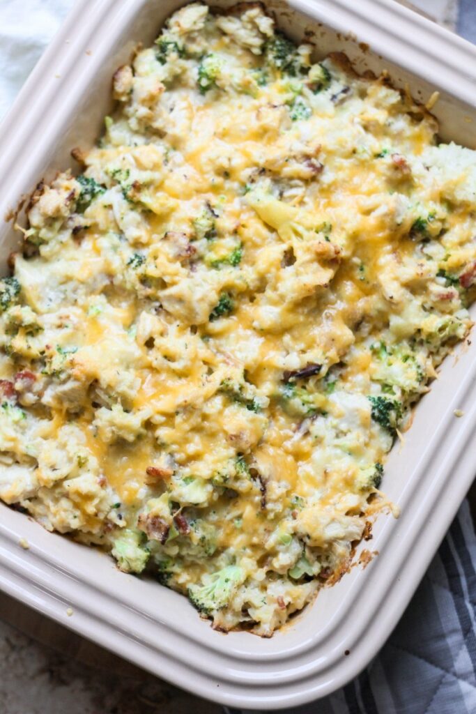 cheesy chicken bacon broccoli casserole atop a wooden table