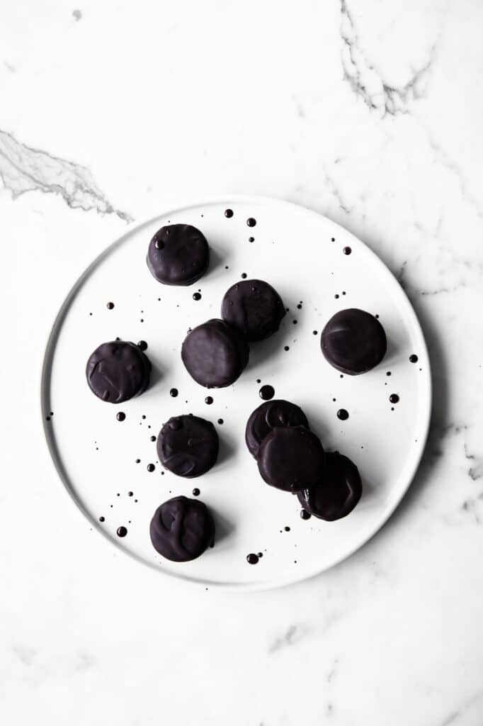overhead shot of Dark Chocolate Peppermint Patty Fat Bombs on a plate atop a marble kitchen counter