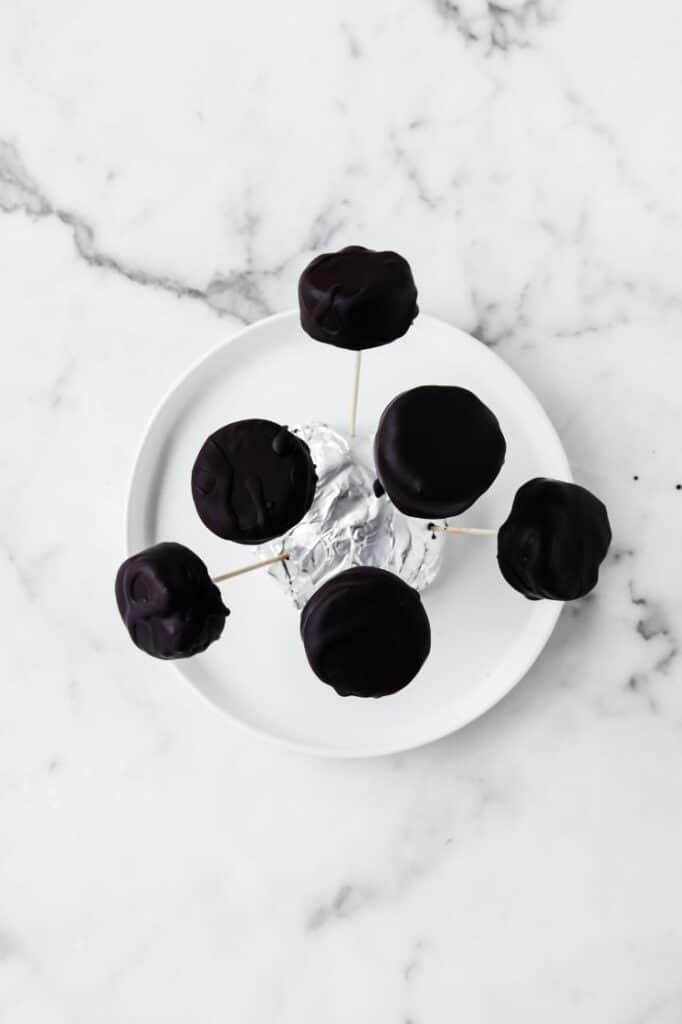 6 Dark Chocolate Peppermint Patty Fat Bombs on a plate fresh from from the fridge atop a marble kitchen counter
