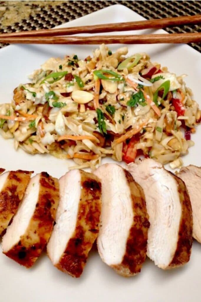 asian grilled chicken with peanut ginger slaw on a plate with chopsticks on the corner of the plate