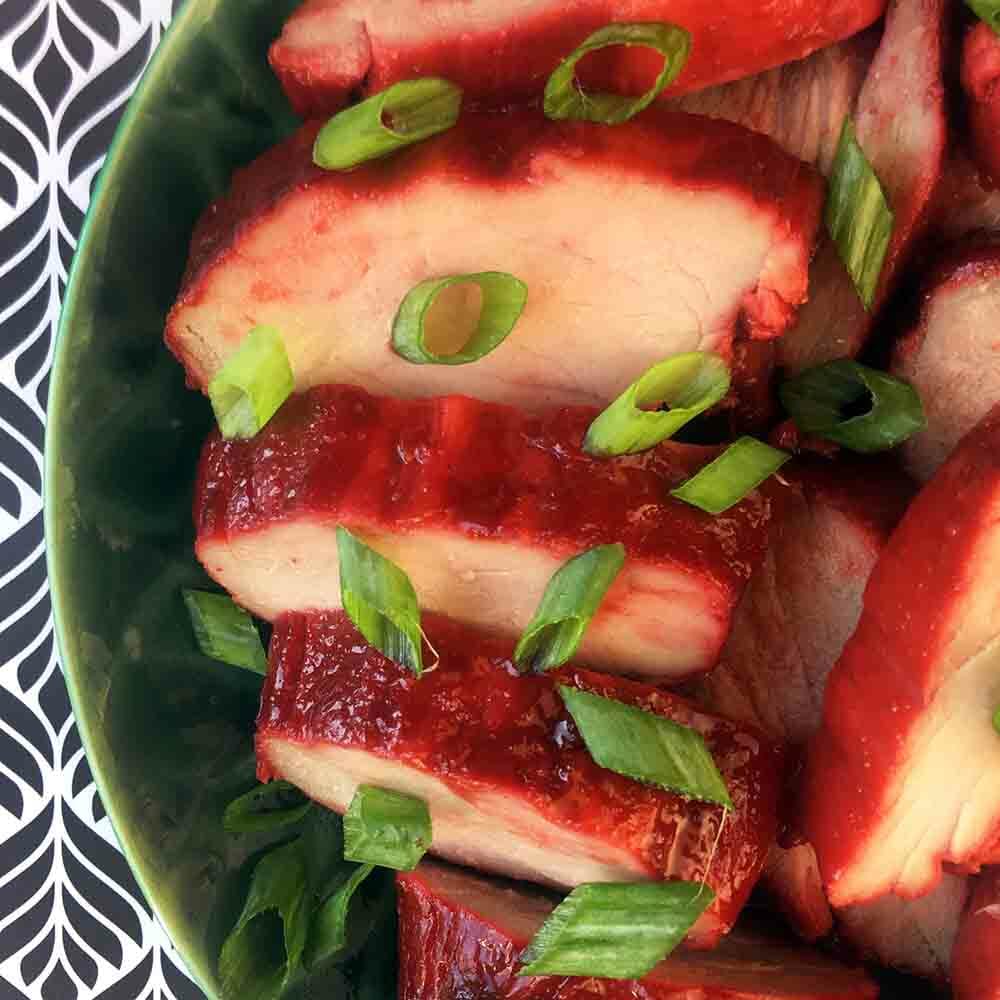 Close-up overhead shot of chinese bbq pork on a plate atop a kitchen counter