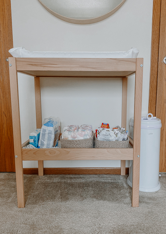 wooden diaper changing station with diaper pad and diapers