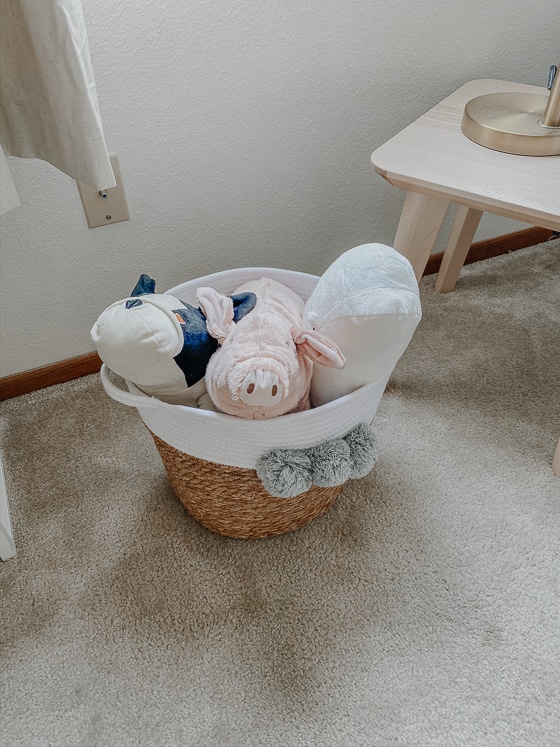 woven toy basket with stuffed animals inside for girl nursery