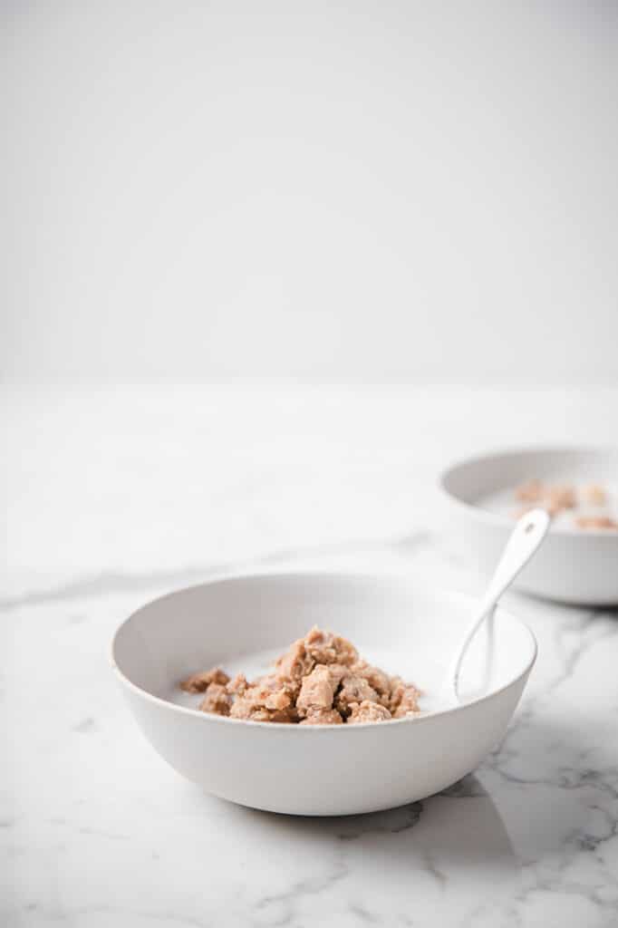 A bowl of cinnamon toast crunch cereal atop a marble kitchen table