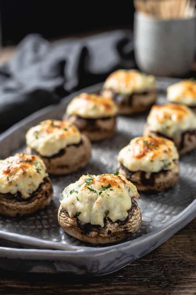 a tray full of crab stuffed mushrooms with cream cheese