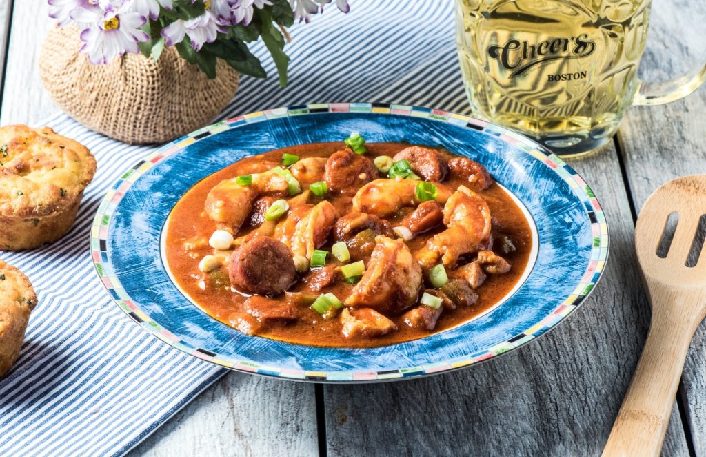 angled shot of keto shrimp gumbo with sausages atop a wooden table