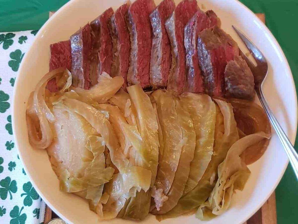 low carb crock pot corned beef and Cabbage on a plate atop a table for St. Patrick's Day Keto Recipes Roundup