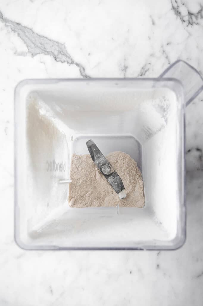 dry ingredients mixed using an electric mixer atop a marble kitchen table.