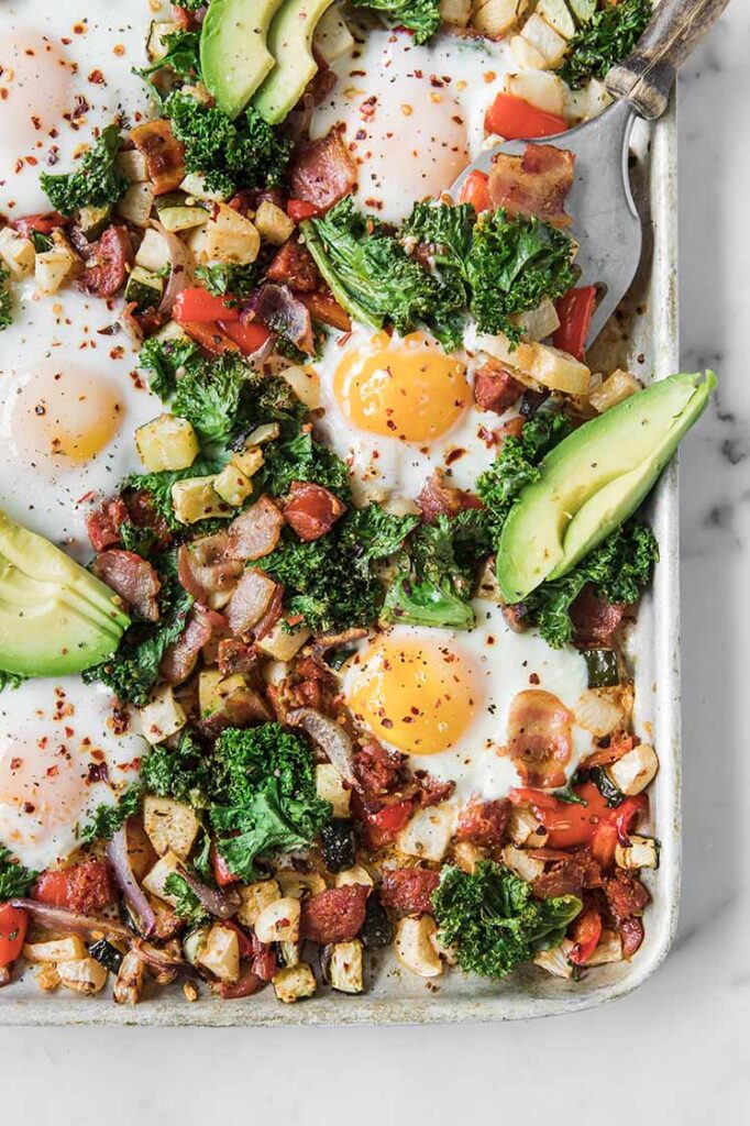 close-up shot of keto sheet pan breakfast hash topped with avocadoes
