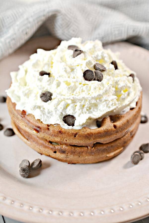 close-up shot of low carb peanut butter chocolate chaffle topped with whipped cream and chocolate chips