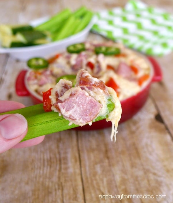 a piece of celery dipped in low-carb cajun andouille cheese dip