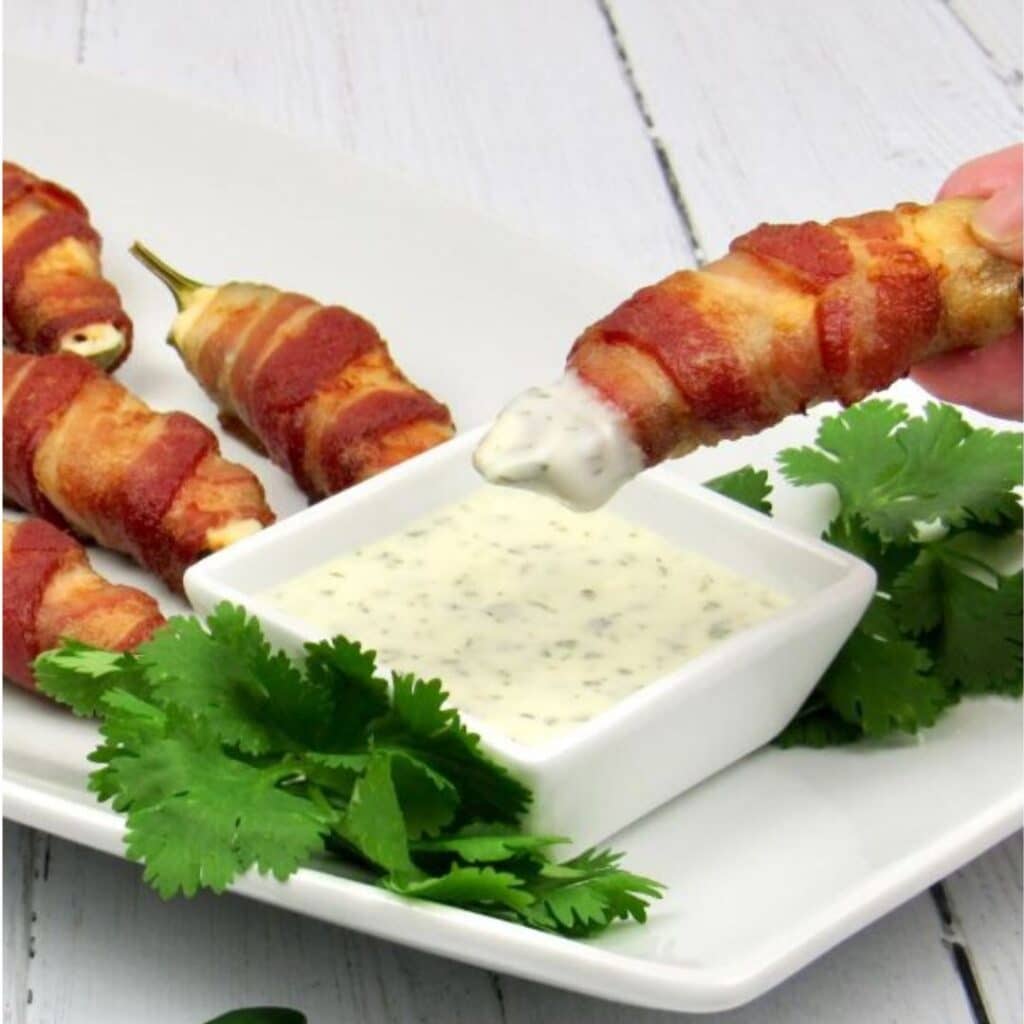 Air Fryer Bacon Wrapped Jalapeño Poppers on a plate atop a kitchen table