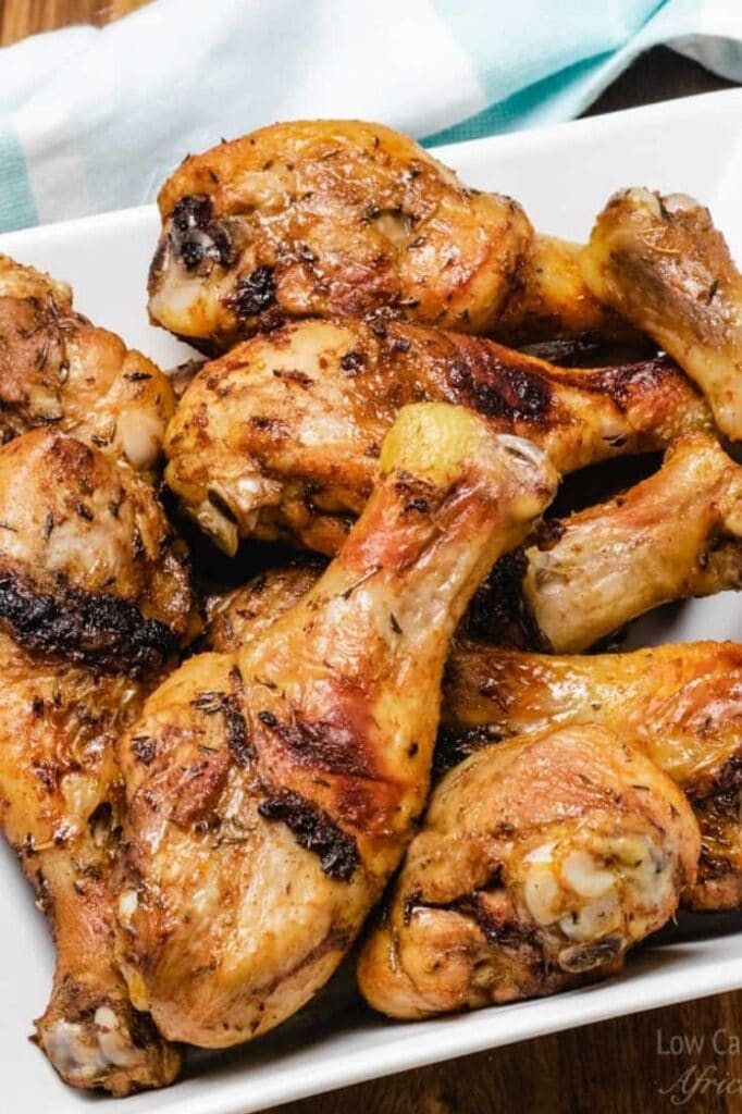 close-up image of crispy skin baked chicken drumsticks on a plate