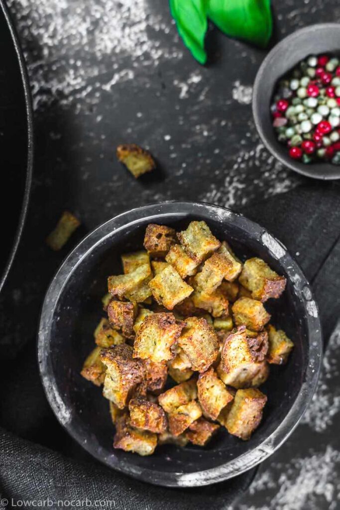 crispy garlic keto croutons in a mortar atop a kitchen table