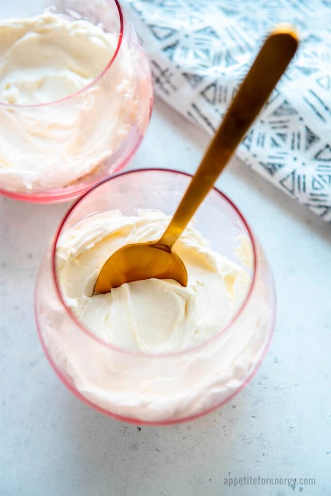 a glass of vanilla cheesecake pudding on a table