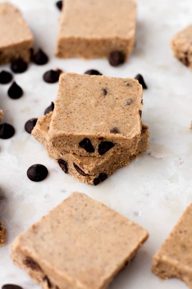 stack-of-no-bake-chocolate-chip-almond-butter-fat-bomb-bars-surrounded-by-pascha-chocolate-chips