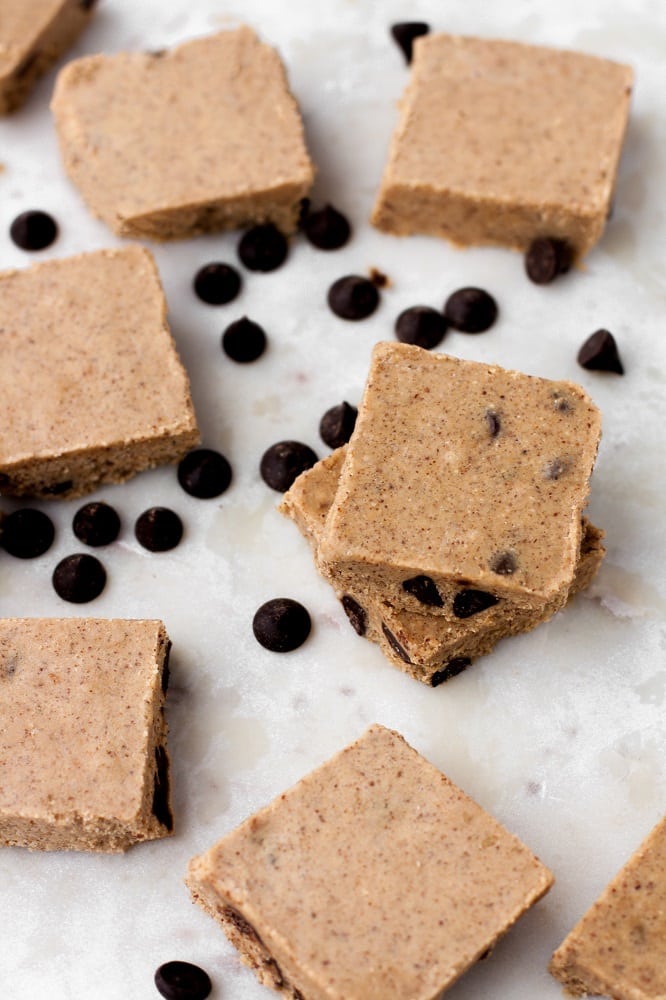 overhead-shot-of-no-bake-chocolate-chip-almond-butter-fat-bomb-bars-surrounded-by-pascha-chocolate-chips