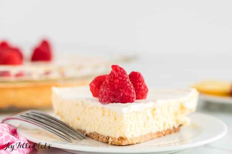 close-up image of a slice of lemon cheesecake with sour cream on a plate