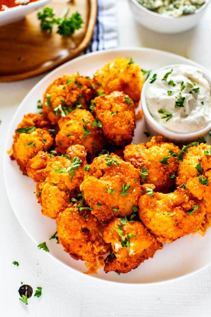 keto cauliflower wings on a plate atop a marble kitchen table