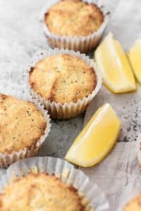 keto-lemon-poppy-seed-muffins beside sliced lemons