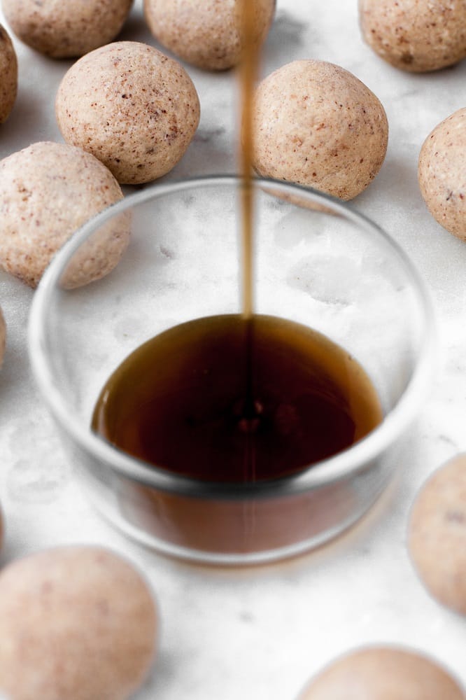 french toast fat bombs beside a small glass container being filled with lakanto maple flavored syrup