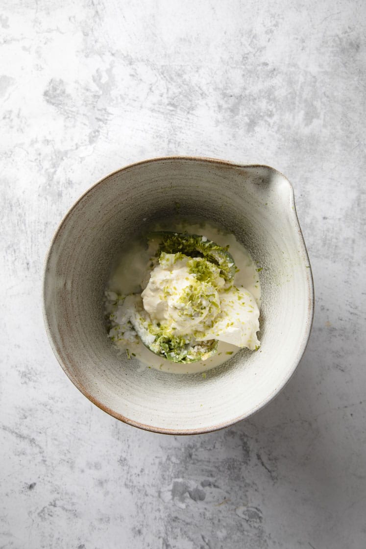 a bowl of pitted avocados, cream cheese, heavy whipping cream, melted butter, powdered monk fruit sweetener, lime zest and lime juice
