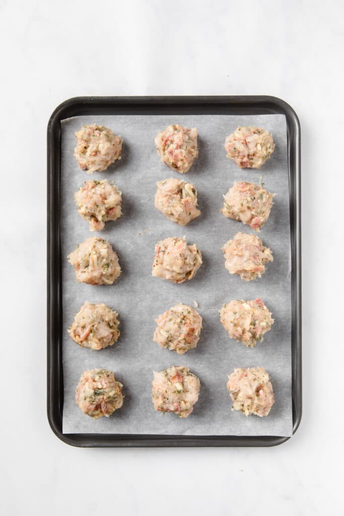 popper mixture formed into an equal-sized balls and placed on top of a baking sheet