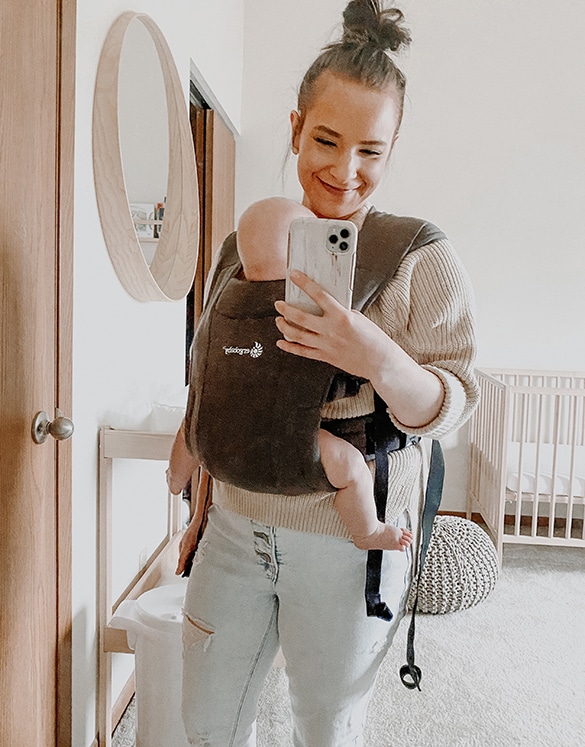 sara nelson taking mirror selfie with cell phone with baby in carrier in nursery