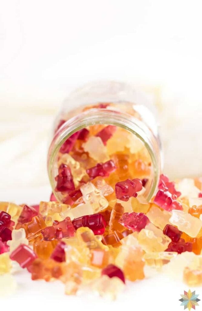 a jar full of spilled homemade gummy bears atop a marble kitchen table