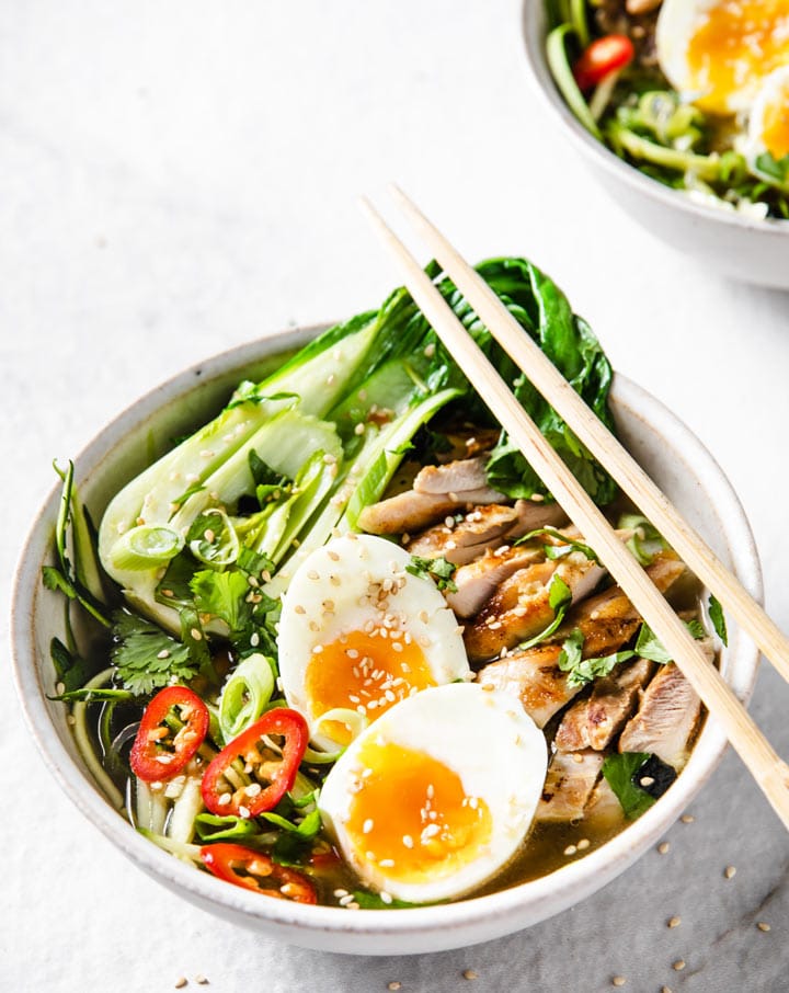 a bowl of low carb keto chicken ramen atop a marble kitchen table