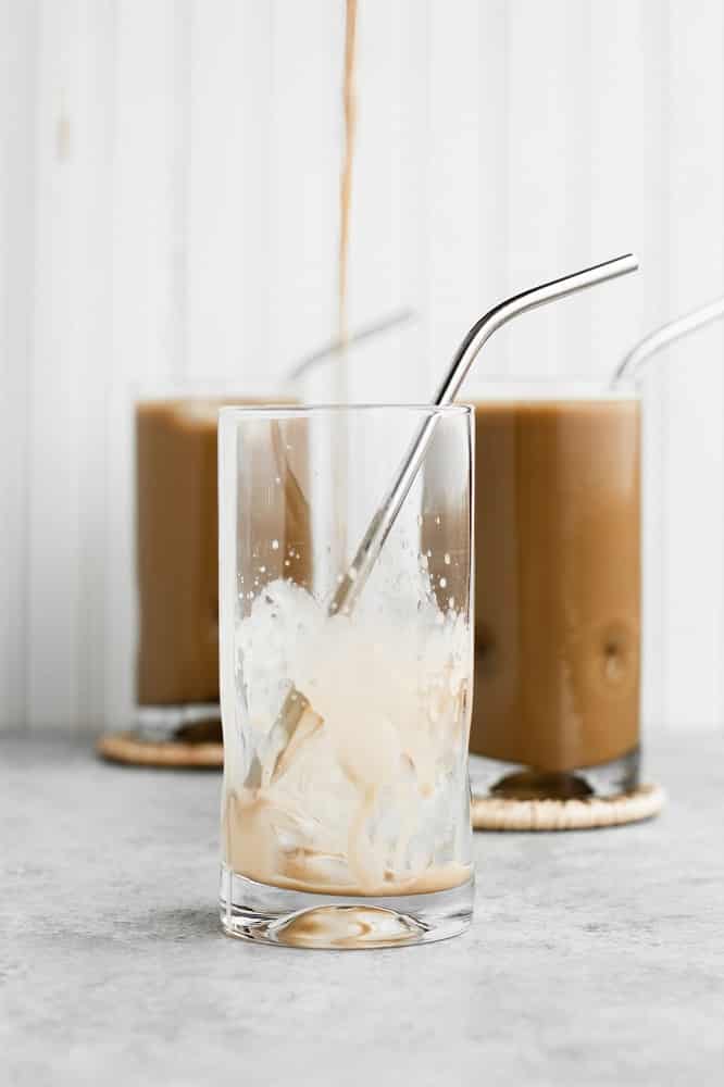 pouring-of-Nut-Free-Dairy-Free-Creamy-Cold-Brew-Keto-Coffee-into-glass-with-ice-and-stainless-steel-straw