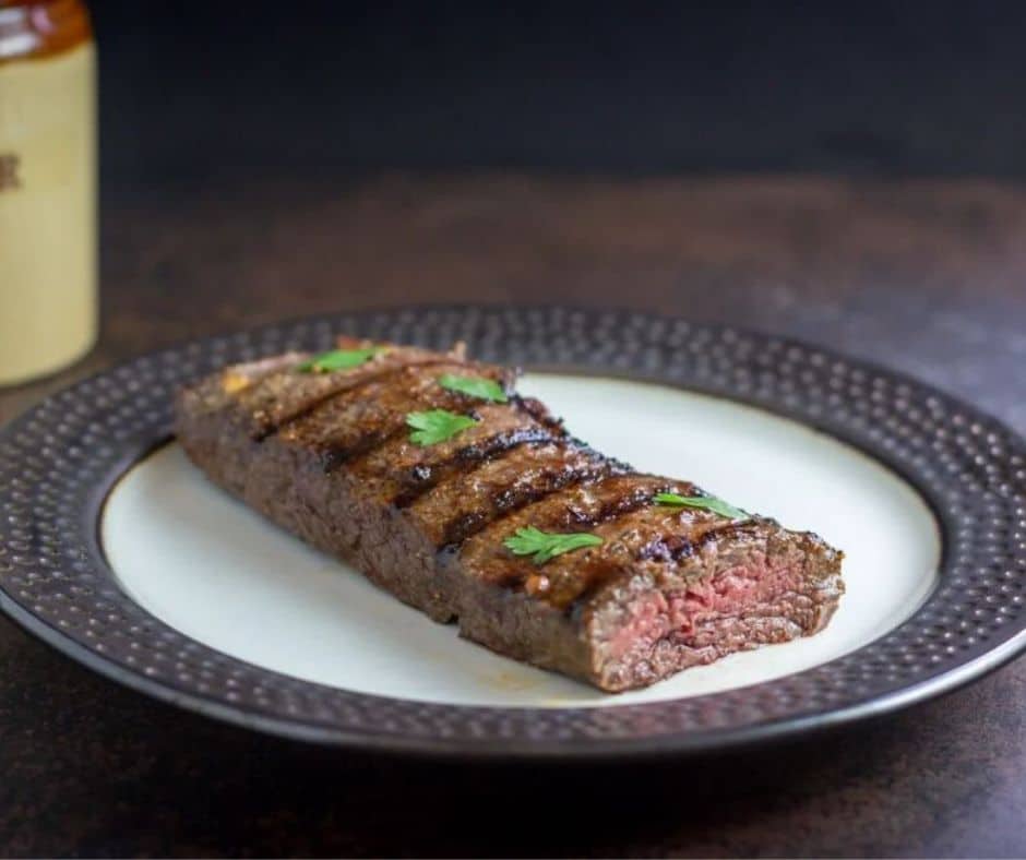 keto father's day recipes Grilled Mojo Skirt Steak on a ceramic plated atop a wooden table