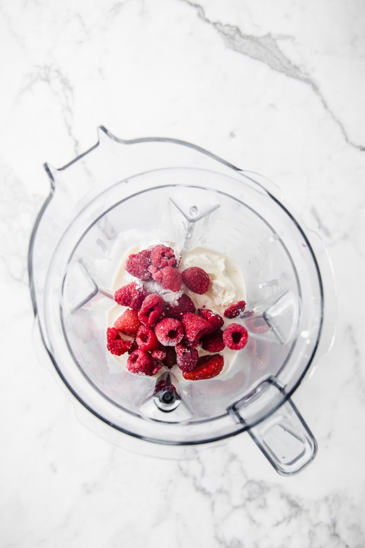 berries, mascarpone, heavy cream and monk fruit sweetener in a blender atop a marble kitchen table