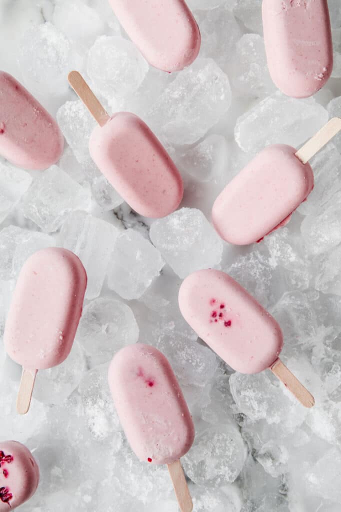 overhead shot of pink keto popsicles atop ice cubes