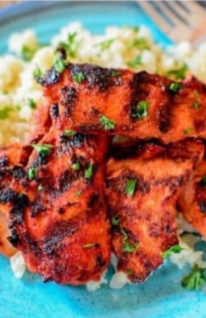 close-up image of chicken tandoori on a plate with cauliflower rice