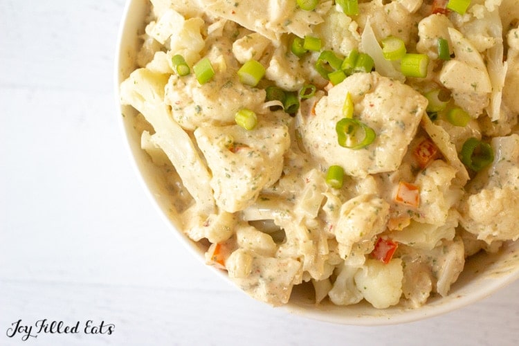 4th of July Keto Recipes - overhead image of a bowl of cauliflower potato salad atop a white wooden table