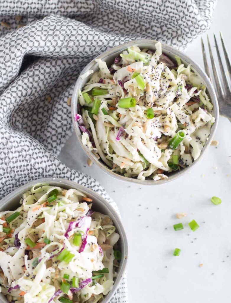keto father's day recipes overhead image of two bowls of coleslaw atop a marble kitchen counter