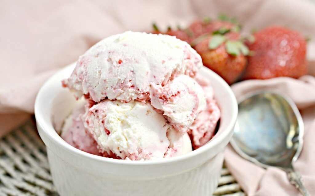 keto strawberry ice cream in an ice cream bowl atop a wooden table