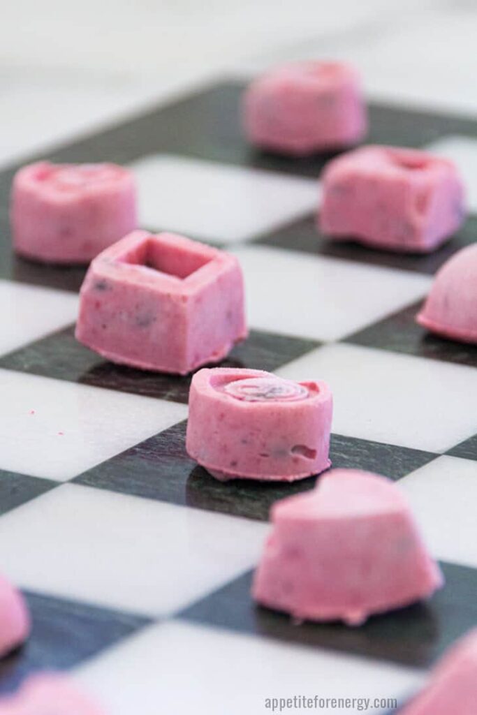 angled shot of keto chocolate strawberry ice cream bites on a checkered patterned table